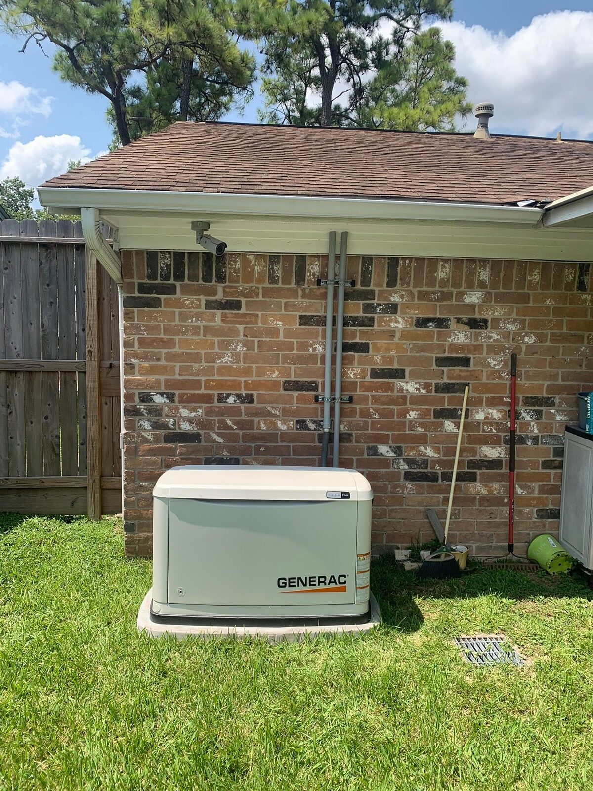 Completed Generac generator installation beside a brick home